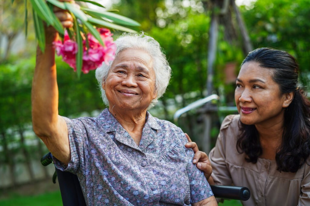 Caregiver help Asian elderly woman disability patient sitting on